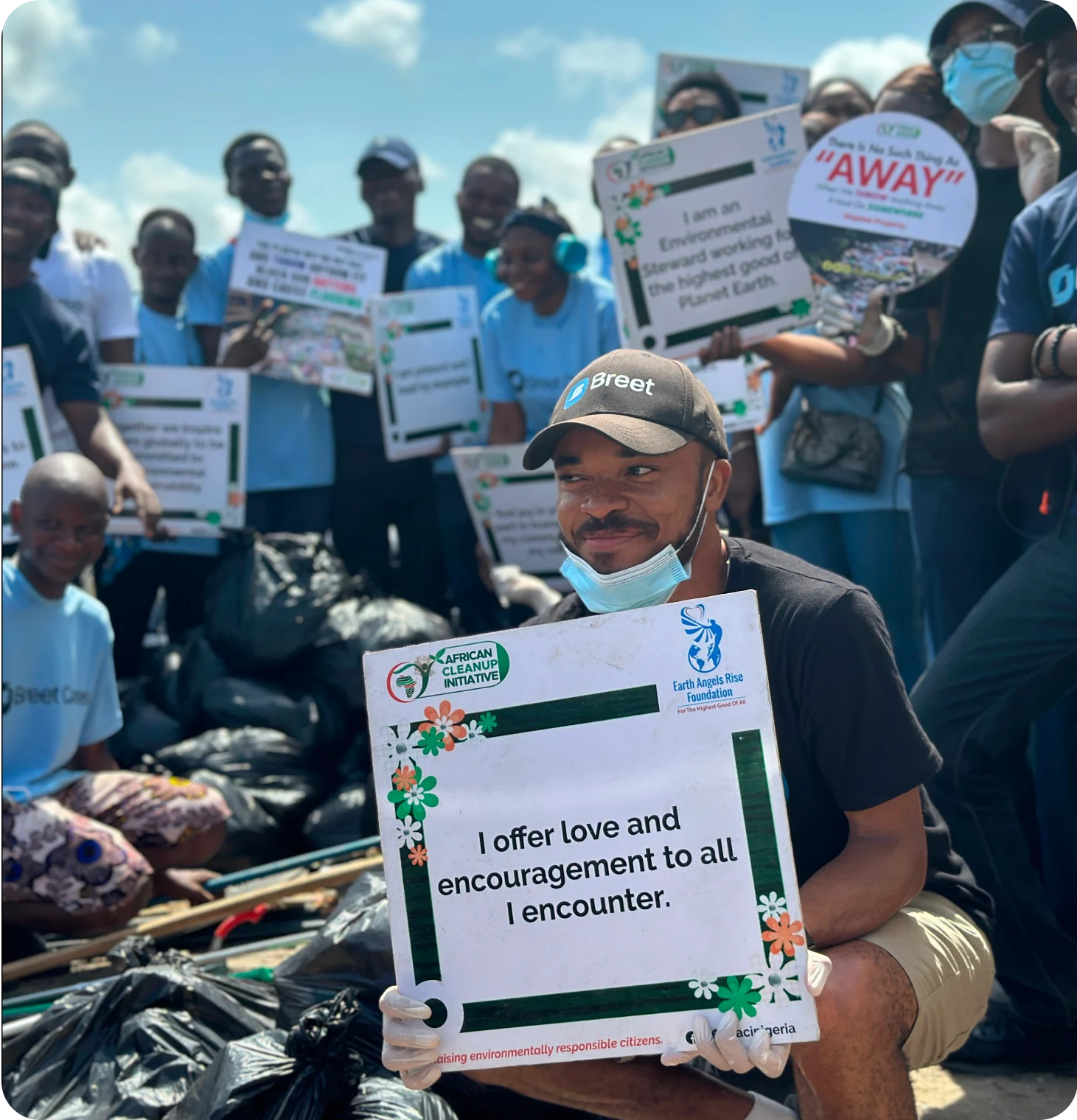 a man squating and holding a placard